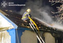A rescuer extinguishes a fire on the roof of a private house