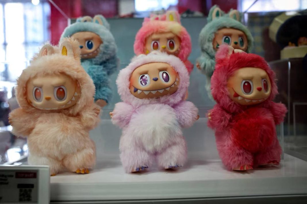 Labubu toy on the background of Sony Pictures and Pop Mart logos