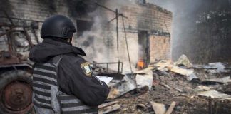 Police and rescuers inspect a destroyed residential building after the shelling.
