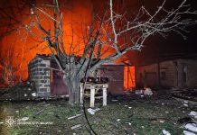 Rescuers extinguish a fire after shelling.