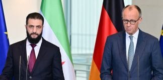 Фрідріх Мерц виступає перед пресою на тлі німецького прапора