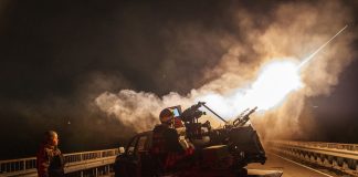 Ukrainian soldiers against the backdrop of an air defence system during a night attack