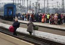 Passengers leave a railway station during an air raid alert
