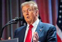 Дональд Трамп під час пресконференції, фон – прапор США