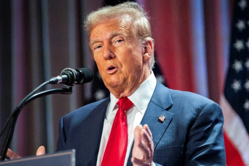 8e6cd3d30fe2460b9381383af1963cbd Дональд Трамп під час пресконференції, фон – прапор США