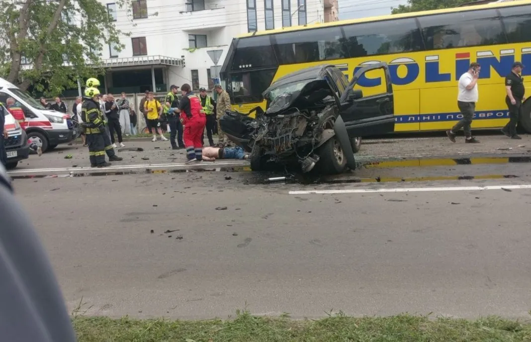 Screenshot_1 Жовтий пасажирський автобус із пошкодженим переднім склом і чорний легковий автомобіль після аварії на вулиці Київський Шлях у Борисполі.