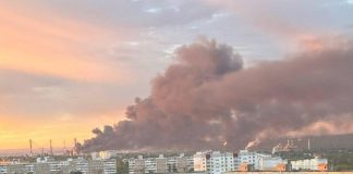 Fire at an oil refinery in Saratov after a drone attack with thick black smoke in the background.