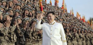 North Korean leader Kim Jong Un greets soldiers during a mass military event