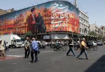 A street in Tehran featuring a large mural dedicated to Iran and its religious leadership