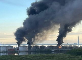 A fire at an oil terminal in St. Petersburg after a drone attack, against a backdrop of thick black smoke.