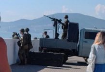 Adler's beaches are turning into military bases Military with a heavy machine gun on the beach in Adler among holidaymakers
