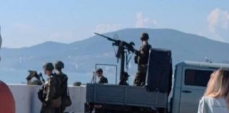 Adler's beaches are turning into military bases Military with a heavy machine gun on the beach in Adler among holidaymakers