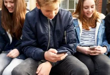 Кінець епохи TikTok та Instagram: Британія офіційно забороняє соцмережі для підлітків Підлітки користуються смартфонами, на екранах — логотипи соцмереж, що підпадають під заборону у Великобританії.