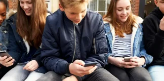 The UK government has announced a ban on social media for users under the age of 16, to come into effect this spring Підлітки користуються смартфонами, на екранах — логотипи соцмереж, що підпадають під заборону у Великобританії.