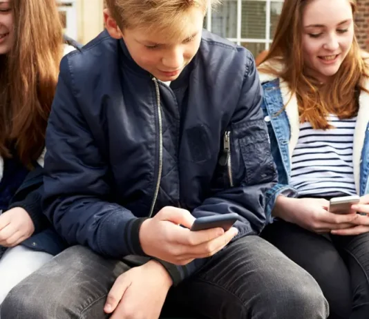 Кінець епохи TikTok та Instagram: Британія офіційно забороняє соцмережі для підлітків Підлітки користуються смартфонами, на екранах — логотипи соцмереж, що підпадають під заборону у Великобританії.