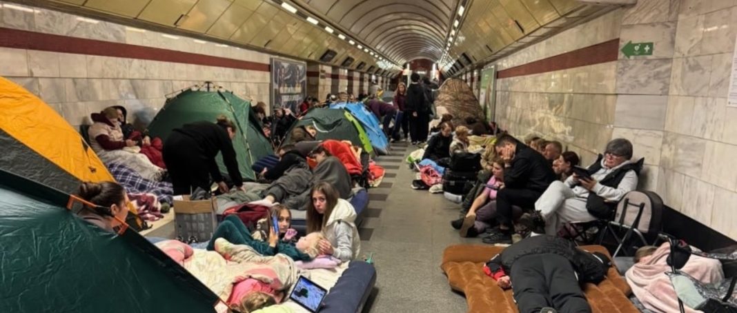 Люди в метро Києва під час повітряної тривоги з речами для тривалого перебування в укритті.