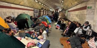 People in the Kyiv metro during the air raid with things for a long stay in the shelter.