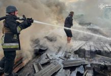 Firefighters extinguish a fire in a warehouse building after a drone attack in Chernihiv region.