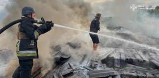 Firefighters extinguish a fire in a warehouse building after a drone attack in Chernihiv region.
