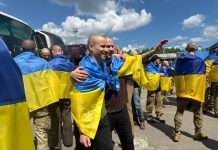 The liberated Ukrainian defenders return to their homeland surrounded by support and flags.