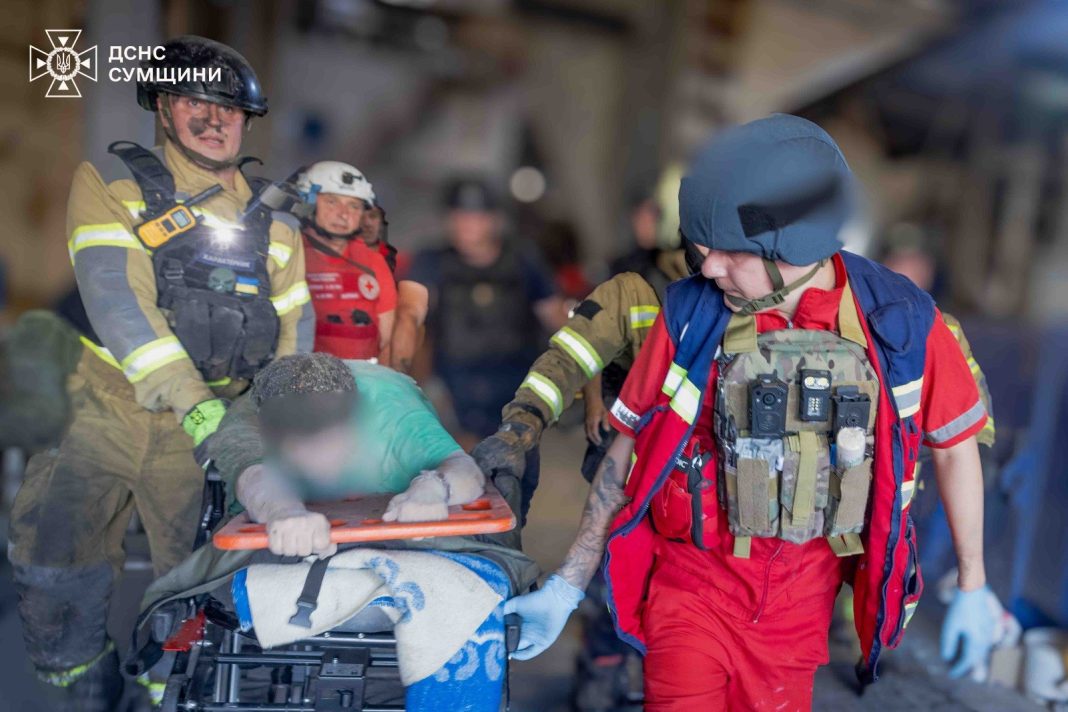 Rescue workers from the State Emergency Service are working at the scene of the air strike in Sumy.