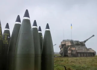 Артилерійські боєприпаси на тлі самохідної артилерійської установки