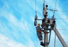 An electricity engineer is carrying out repairs to a high-voltage power line following damage to the network.