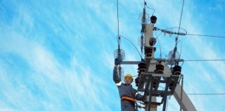 An electricity engineer is carrying out repairs to a high-voltage power line following damage to the network.