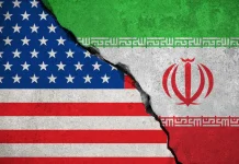 Iran has claimed that the US carried out a strike on an unfinished nuclear power station in Darhovin The flags of the US and Iran against the backdrop of the escalating conflict between the two countries