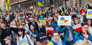 Ukrainians and Poles carrying Ukrainian and Polish flags at a rally in support