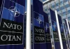 НАТО затвердило рекордну допомогу Україні: €70 млрд у 2026 році Логотип НАТО на фоні прапора України