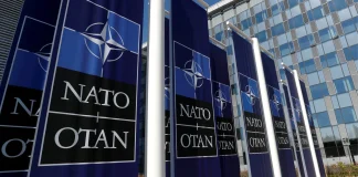 НАТО затвердило рекордну допомогу Україні: €70 млрд у 2026 році Логотип НАТО на фоні прапора України