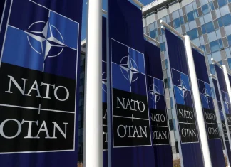 НАТО затвердило рекордну допомогу Україні: €70 млрд у 2026 році Логотип НАТО на фоні прапора України