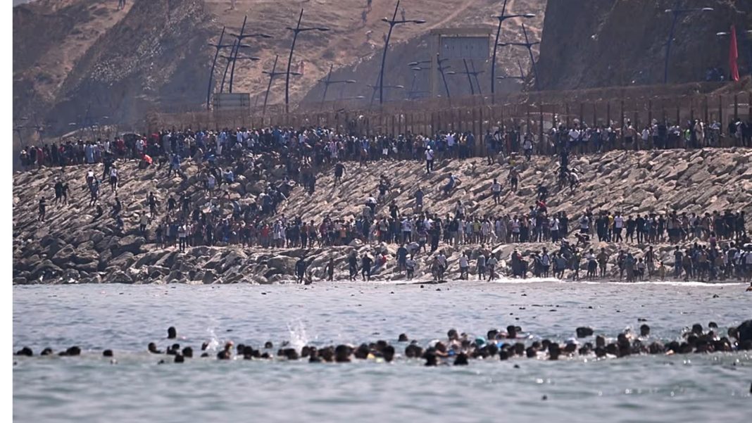 Ceuta People are gathered near the border fence in Ceuta following a mass influx from Morocco