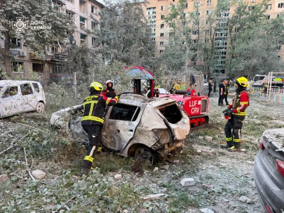 Rescue workers from the State Emergency Service are working near burnt-out cars and damaged buildings following the attack on Kyiv.