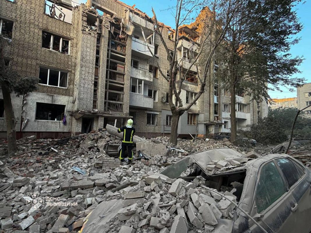 Rescue workers are at the scene of a residential building in Lviv that was damaged by a missile strike