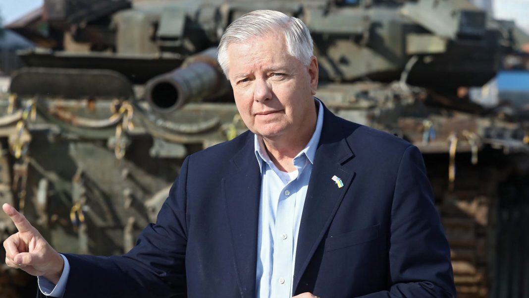 Senator Lindsey Graham against a backdrop of military equipment Senator Lindsey Graham