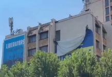 Демонтаж великого прапора України та банера Free Ukraine на будівлі в центрі Приштини