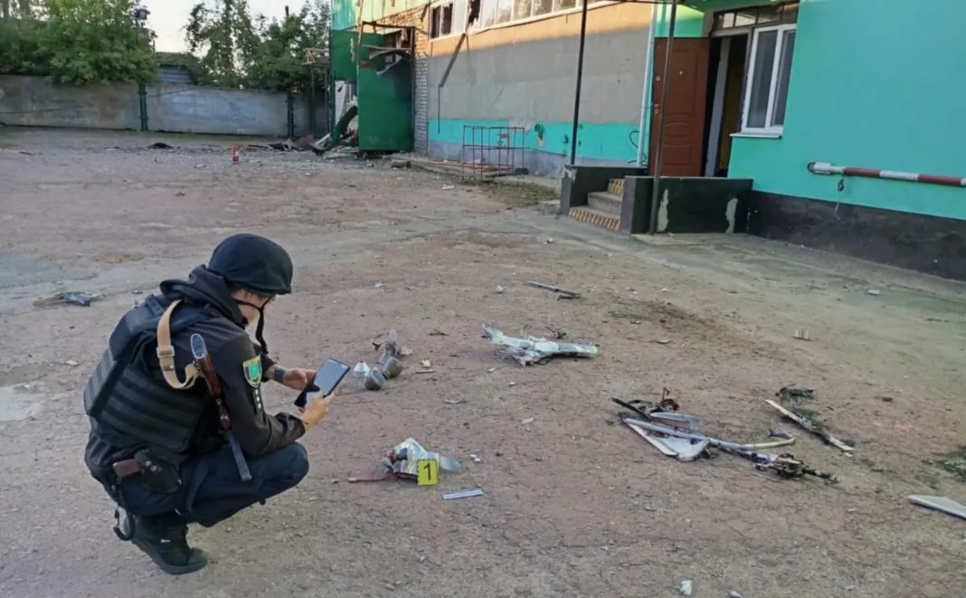 Screenshot_3 оліцейська фотографує уламки російського БпЛА біля пошкодженого будинку на Сумщині