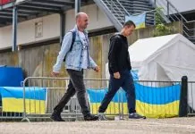 Українські чоловіки біля центру допомоги з прапорами України