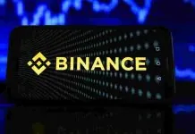 Binance обмежила операції російських користувачів через санкції ЄС Логотип криптобіржі Binance на темному тлі