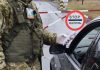 Український прикордонник перевіряє документи водія на пункті пропуску