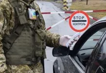 Український прикордонник перевіряє документи водія на пункті пропуску