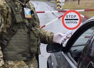 Український прикордонник перевіряє документи водія на пункті пропуску