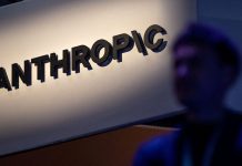 Anthropic has warned investors about the existential risks posed by AI The Anthropic logo on the screen alongside text about the risks of artificial intelligence