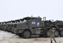 From cars to weapons: British factories are preparing to switch production British military armoured vehicles in a parking area