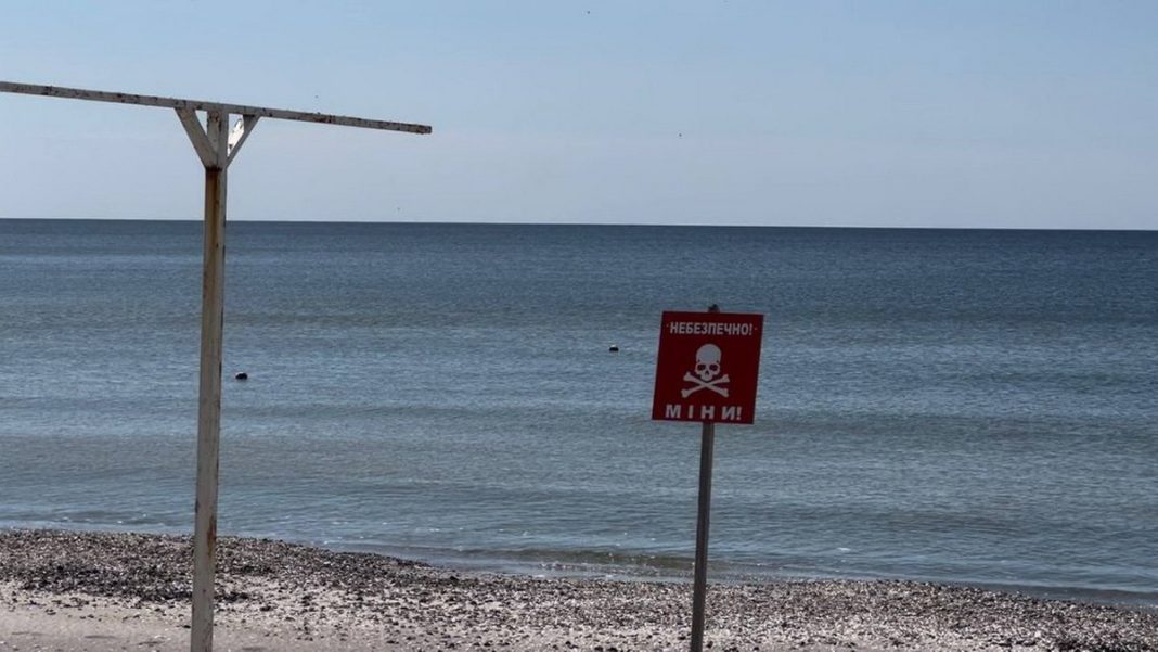 Fencing and a warning sign about the danger of mines on the coast