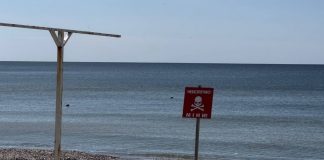 Fencing and a warning sign about the danger of mines on the coast