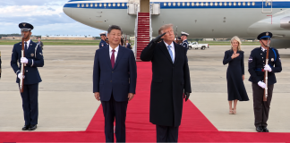 Donald Trump and Xi Jinping on the red carpet by the aeroplane, flanked by an honour guard.