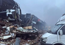 Зруйнована будівля «Нової пошти» та пошкоджені вантажівки серед уламків після російської атаки.